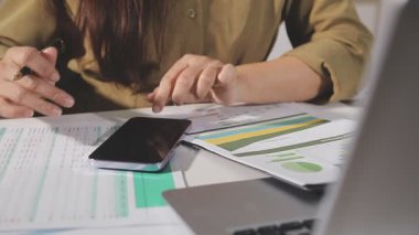 Hesap makinesi ve kalem tutan kadın.