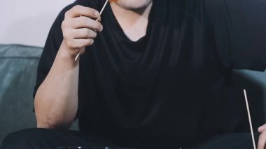 Genç adam masada suşi yiyor.