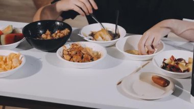 Tavuk ve sebzeli kızarmış pirinç yiyen Asyalı kadın.