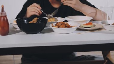 Adam lokantada çubukla Asya eriştesi yiyor.