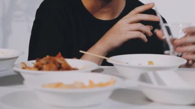 Asyalı bir adam kasede erişte yiyor.