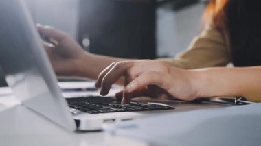 Dizüstü bilgisayarda çalışan genç bir kadın.