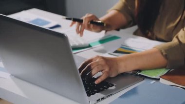 Ofiste kredi kartı ve dizüstü bilgisayarı olan genç bir kadın var.