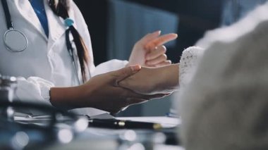 Bir hastanın elini tutan kadın doktora yaklaş.