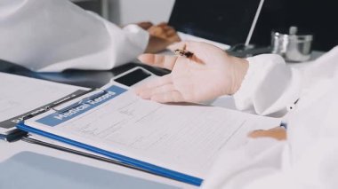 Hastanedeyken beyaz üniformalı doktor panoya yazı yazıyor.