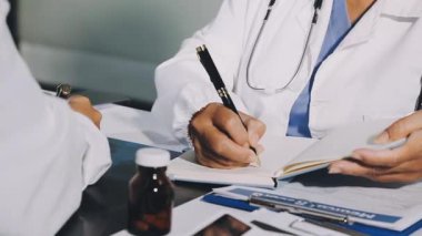 Doktor masadaki tahtaya notlar yazıyor.