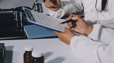 Doktor reçeteyi masadaki kağıda yazarken kapatın.