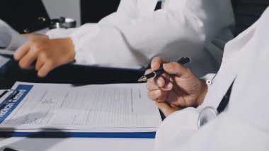 Doktor elinde kalem tutuyor.