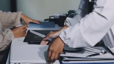 Klinikte dizüstü bilgisayarı olan bir doktor dijital tablet bilgisayar kullanırken,