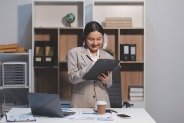 Asyalı iş kadını şirketin başarısı hakkında mutlu bir şekilde çalışıyor, finansal raporu analiz etmeyi planlıyor, iş planı yatırımı, finans analizi kavramı.