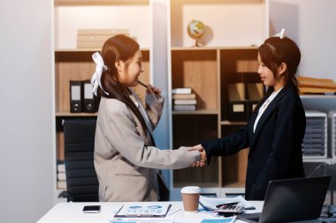 İş adamları yeni çalışanları tebrik etmek için ofiste görüştükten sonra el sıkışıyor..