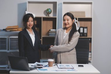 İş adamları yeni çalışanları tebrik etmek için ofiste görüştükten sonra el sıkışıyor..