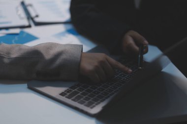 Modern dizüstü bilgisayarla gelir tabloları ve grafiklerini analiz eden iş ekibini kapatın. İş analizi ve strateji kavramı.