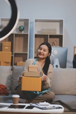 Genç Asyalı kadınlar müşterilerden gelen yeni siparişten sonra mutlu olurlar. Asyalı bir kadının online mağazasının satışındaki başarısının sürpriz ve şok edici yüzü. Çevrimiçi satış. Çevrimiçi Alışveriş