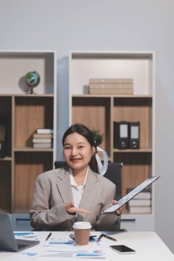 Asyalı iş kadını şirketin başarısı hakkında mutlu bir şekilde çalışıyor, finansal raporu analiz etmeyi planlıyor, iş planı yatırımı, finans analizi kavramı.