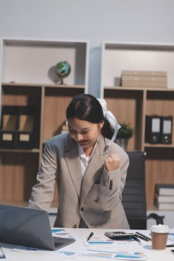 Asyalı iş kadını şirketin başarısı hakkında mutlu bir şekilde çalışıyor, finansal raporu analiz etmeyi planlıyor, iş planı yatırımı, finans analizi kavramı.