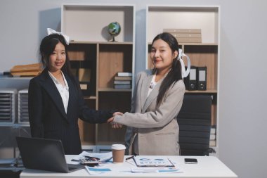 İş adamları yeni çalışanları tebrik etmek için ofiste görüştükten sonra el sıkışıyor..