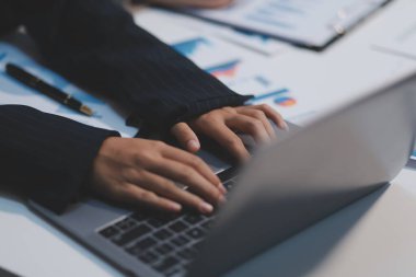 Modern dizüstü bilgisayarla gelir tabloları ve grafiklerini analiz eden iş ekibini kapatın. İş analizi ve strateji kavramı.