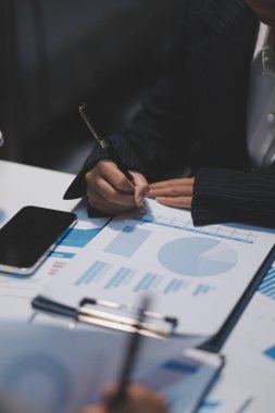 Modern dizüstü bilgisayarla gelir tabloları ve grafiklerini analiz eden iş ekibini kapatın. İş analizi ve strateji kavramı.