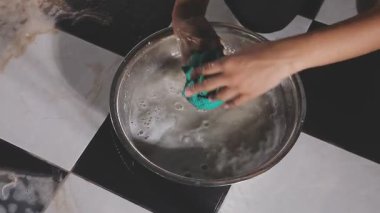 Yakın plan kadın eli sabunla bulaşık yıkarken.