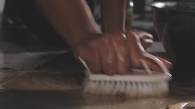 Mutfakta bulaşık yıkayan bir kadının elini kapat.