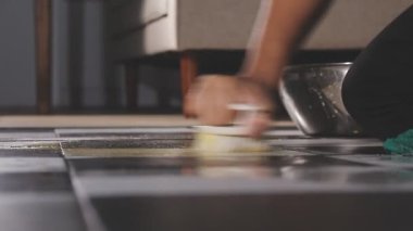 Kadın mutfak zeminini süngerle temizliyor.