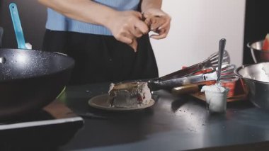 Kadın mutfakta yemek pişiriyor ve yemek yapıyor.