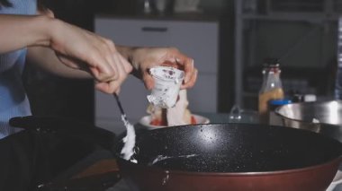 Asyalı kadınların ellerinde tavukla kızartma tavası