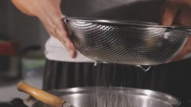 Kadın mutfakta kaşıkla sıcak çikolata yapıyor.