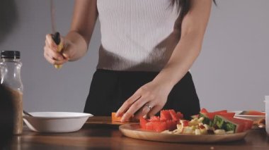 Kadın mutfakta salata hazırlıyor.