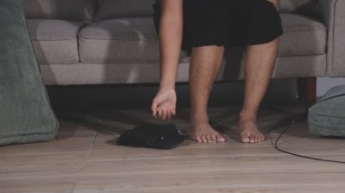 Adam evdeki kanepede video oyunu oynuyor.