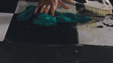 close - up view of a hand in black glove holding a brush for washing dishes.