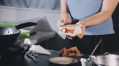 Genç bayan mutfakta yemek hazırlıyor.