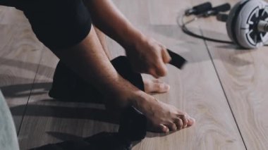 man in a black t - shirt with a pair of shoes in a bathroom