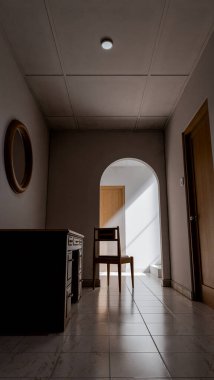 Minimalist 3D bir iç mekan, sandalye, ahşap mobilya ve kemer yolu boyunca doğal ışık. Yalnızlık, tasarım veya mimari sanat kavramları için mükemmel..