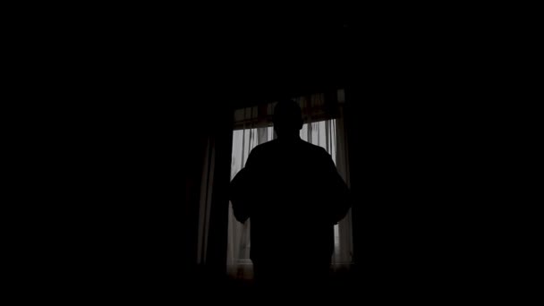 Silhouet van een man gekleed in de kamer — Stockvideo