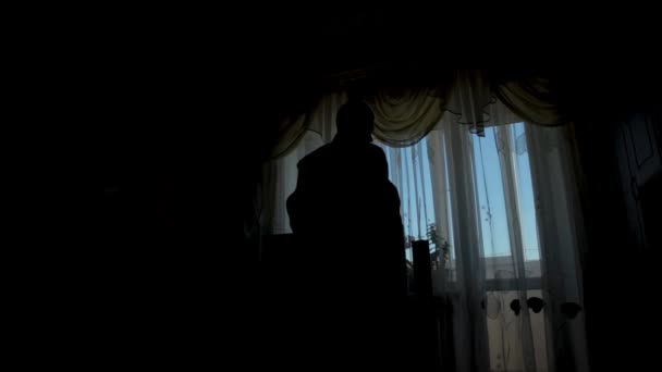 Silhouet van een man gekleed in de kamer — Stockvideo