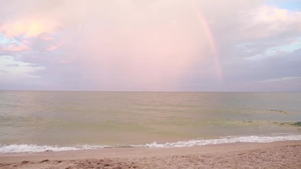 Puesta de sol en el mar, olas, brisa marina, playa. Arco iris después de lluvia . — Vídeos de Stock