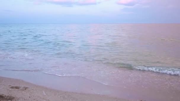 Захід сонця в морі, хвилі, пляж з морським бризом. хвилі змивають сліди людей  . — стокове відео