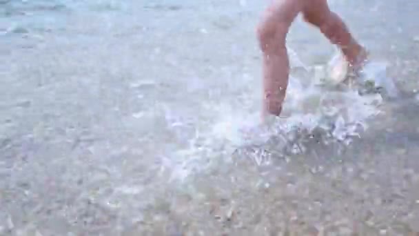 Criança descalça feliz divirta-se na caminhada na praia. Menina correr ao longo do mar surf por piscina de água e saltar com salpicos. Férias de verão com crianças na ilha tropical — Vídeo de Stock