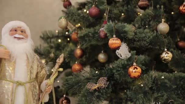 Weihnachtsfest. schön dekoriertes Haus mit einem Weihnachtsbaum. Großaufnahme einer farbigen Christbaumkugel, die an einem geschmückten Weihnachtsbaum hängt. — Stockvideo