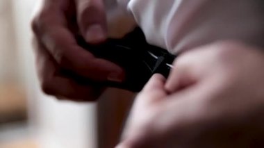 Genç adam pantolon kemerinde düzeltir.