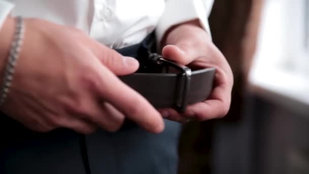 Le jeune homme corrige une ceinture sur un pantalon . — Video