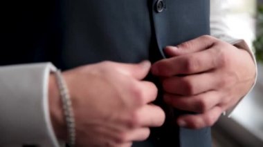 Adam yeleğini düğmede. Close. Son detay için mükemmel. Modern bir işadamı. Şık Klasik takım elbiseli yakışıklı bir genç adam moda vurdu. Mens güzellik, moda.