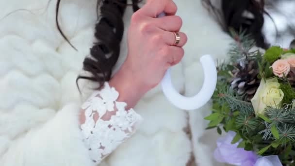 Bouquet da sposa in mano in inverno. Ombrello bianco — Video Stock