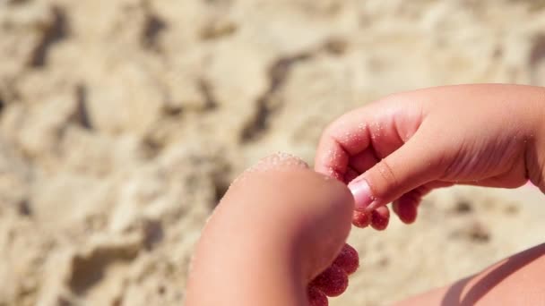 Το παιδί παίζει με άμμο στη καλοκαιρινή παραλία. — Αρχείο Βίντεο