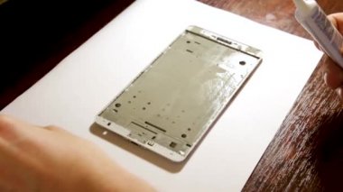 Masabaşında Tornavida ile İnsan Eli Tamir Cep Telefonu Yakın Çekim. Atölyede bozuk akıllı telefonu tamir eden adam. Full Hd