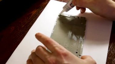 Masabaşında Tornavida ile İnsan Eli Tamir Cep Telefonu Yakın Çekim. Atölyede bozuk akıllı telefonu tamir eden adam. Full Hd