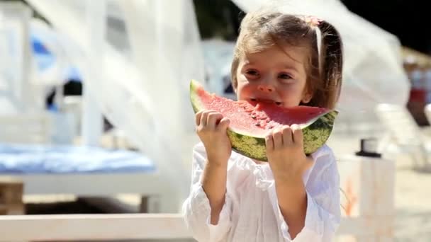 Beyaz Elbiseli Mutlu Küçük Kız Sahilde Karpuz Yiyip Eğleniyor — Stok video