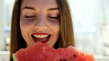 Güzel, seksi kadın, mükemmel saç ve cilt ile kız pozlar ve plajda karpuz yiyor. Piknik.